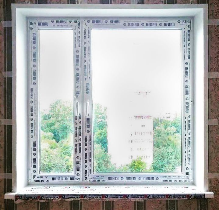Фото: с внутренней стороны окна REHAU имеют защитную пленку с фирменным логотипом без указания конкретной модели, окна профиля рехау