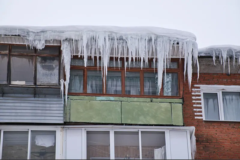 Фото: висящие сосульки на крышах и балконов домов – угроза для здоровья и жизни людей, © depositphotos.com