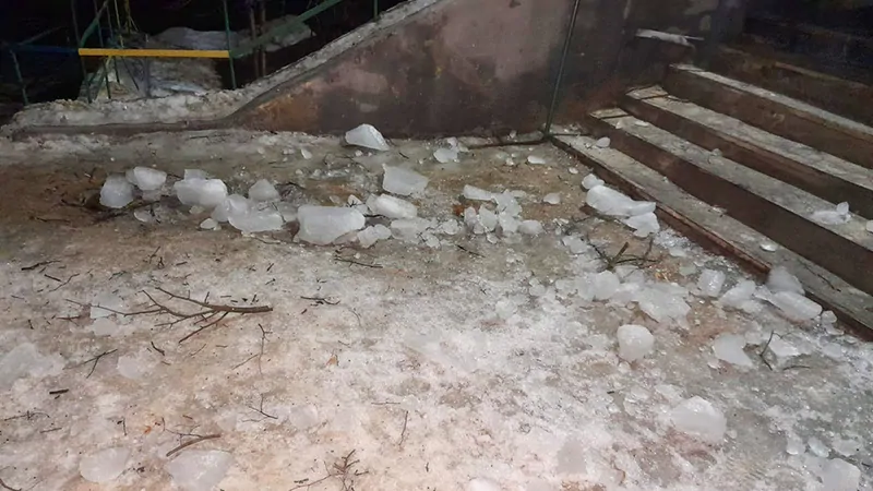 Фото: куски разбившихся ледяных глыб, упавших с крыши 5-этажного дома перед входом в подъезд, © oknamedia.ru 
