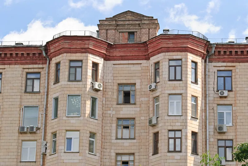 Фото: Разномастные окна на фасаде сталинки портят великолепный облик дома. © Фотобанк Лори 