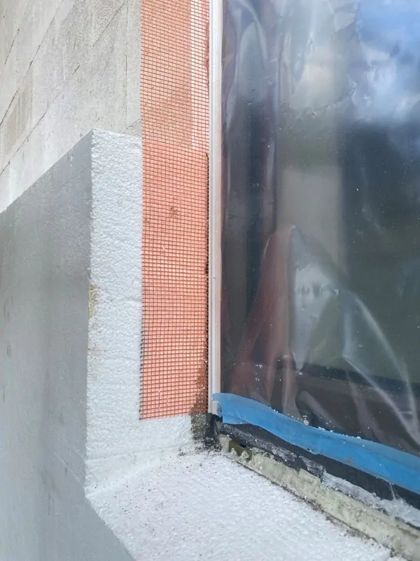 Фото: плиты утеплителя в углах без швов и скошены под отлив. Окна «заподлицо» с домом. Присутствует армирующая сетка для отделки. © oknamedia 