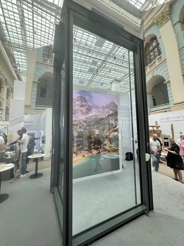 Пивотная дверь с прозрачным заполнением от Ergohaus на АРХ Москва 2025 . © оkna mеdia